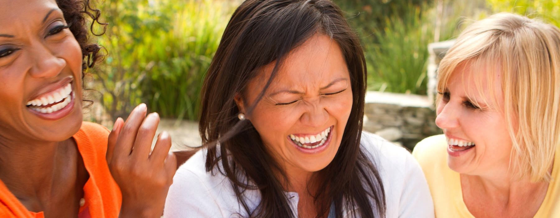 Residents laughing and smiling outside Cornerstone Hauppauge 55 and over apartments on Long Island, NY.