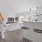 Open concept living area with stairwell leading upstairs, large kitchen, and spacious living room