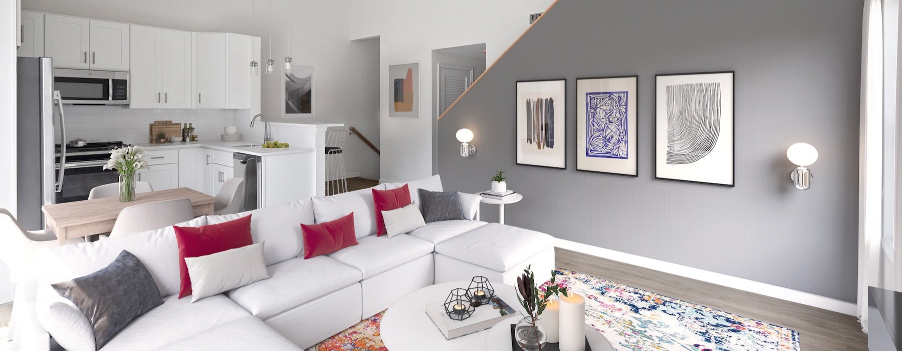Model living room and kitchen at Cornerstone Hauppauge 55 and over apartments on Long Island, NY, featuring white couches.