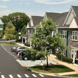 exterior of building with green turf and some seating